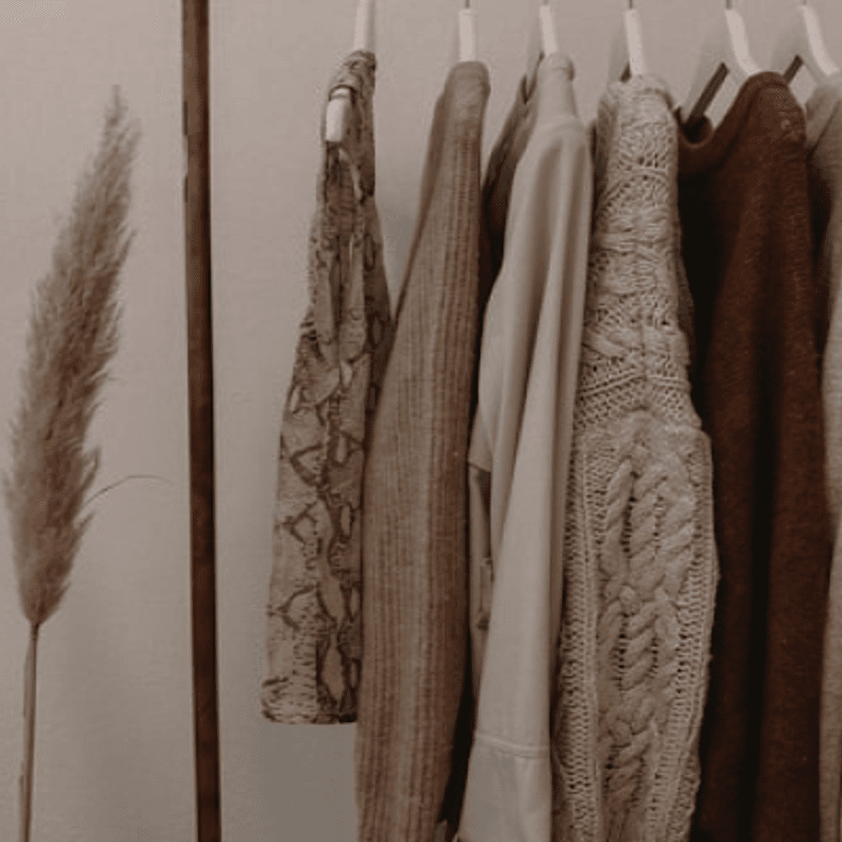 Hand-knitted garments on a wooden rail